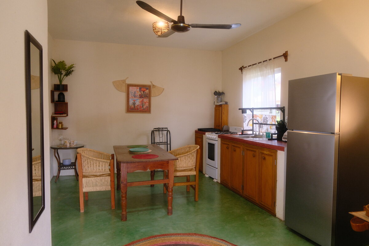 Casa Bel kitchen — full kitchen with a gas range, fridge, and wood dining table