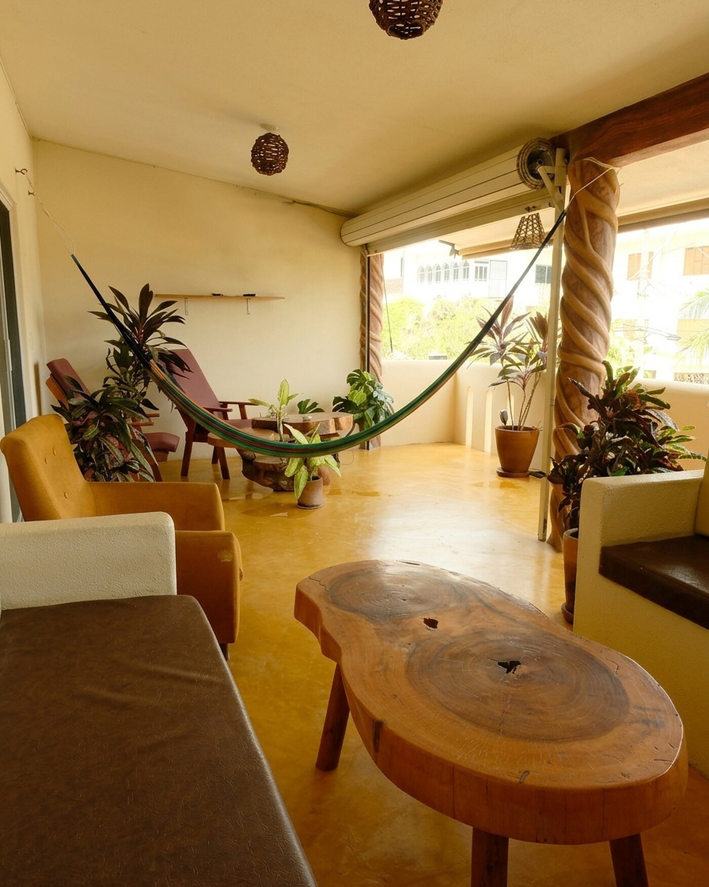 Casa Bel — top-floor terrace with a hammock, live-edge wood table, and open-air afternoon light