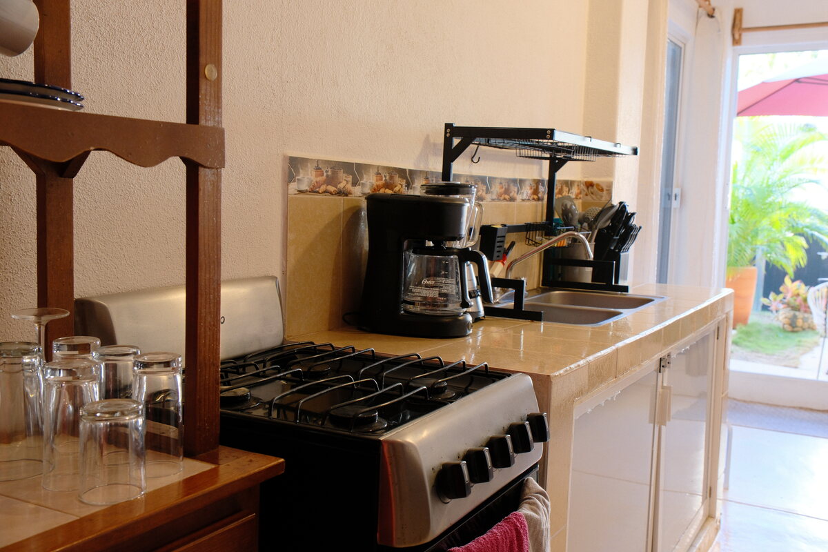 Casa Keiki kitchenette — gas range and coffee maker beside a sunny window