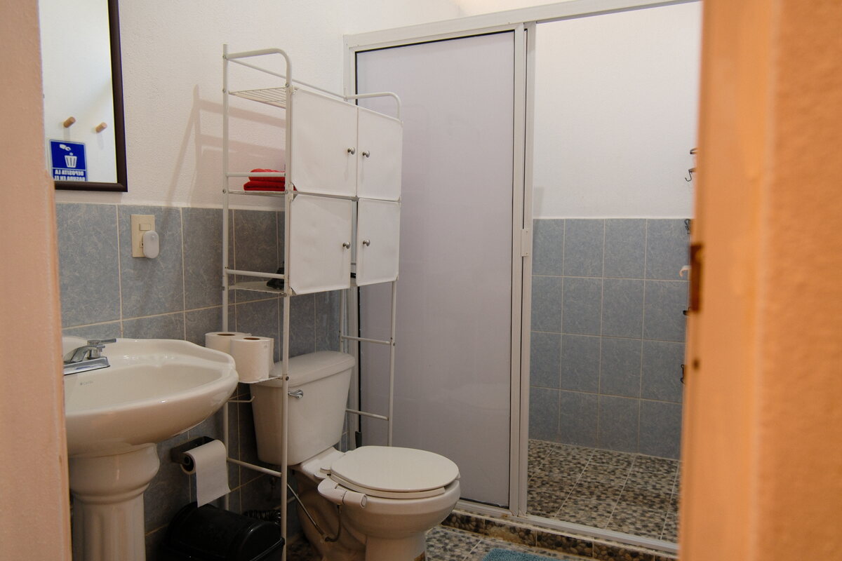 Casa Keiki bathroom — pedestal sink, toilet, and glass-enclosed shower