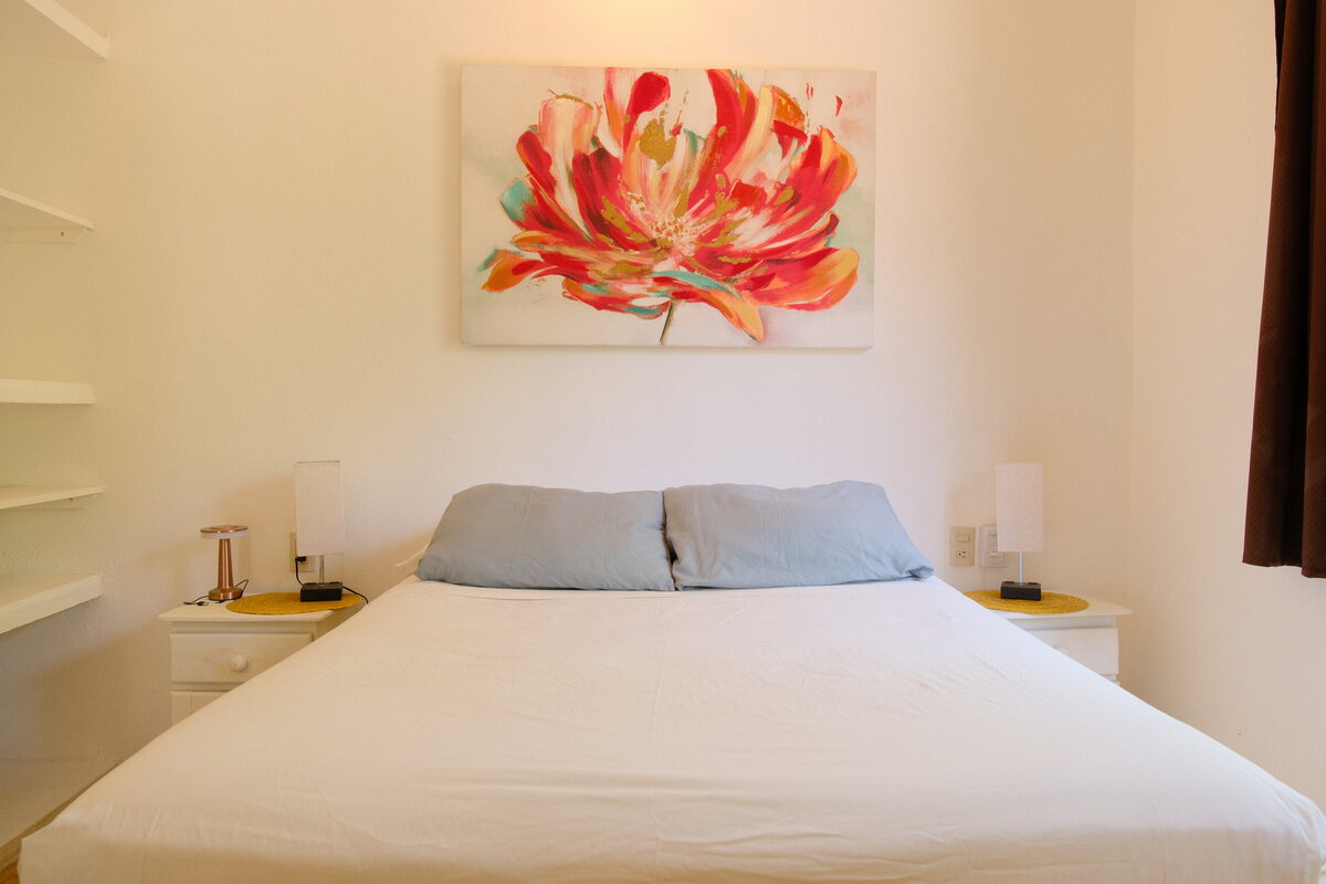 Casa Linda second bedroom — bed beneath a bold floral painting