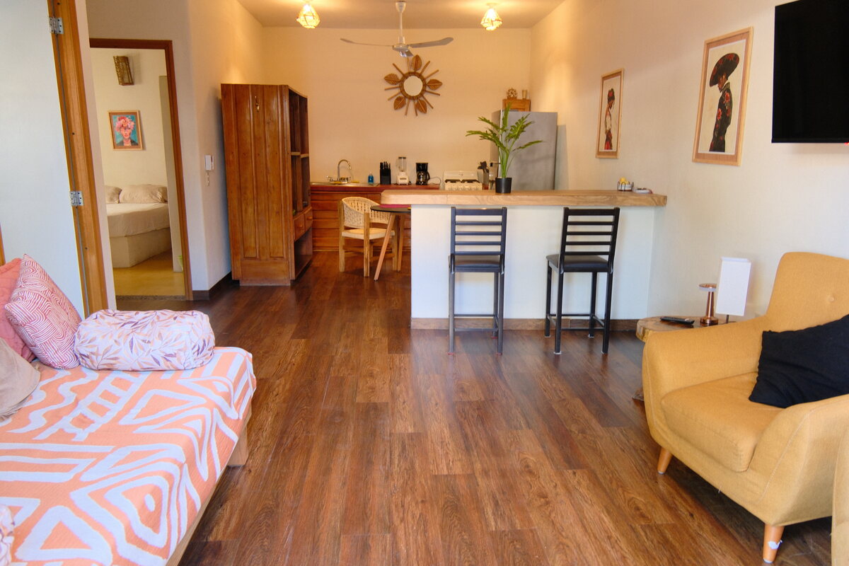 Casa Mia great room — open living and kitchen bar with seating on warm wood floors
