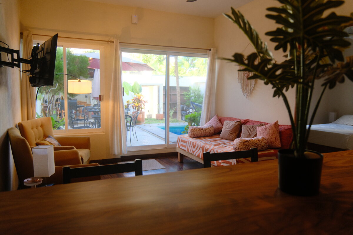 Casa Mia living area — sofa and armchair opening through glass doors to the courtyard