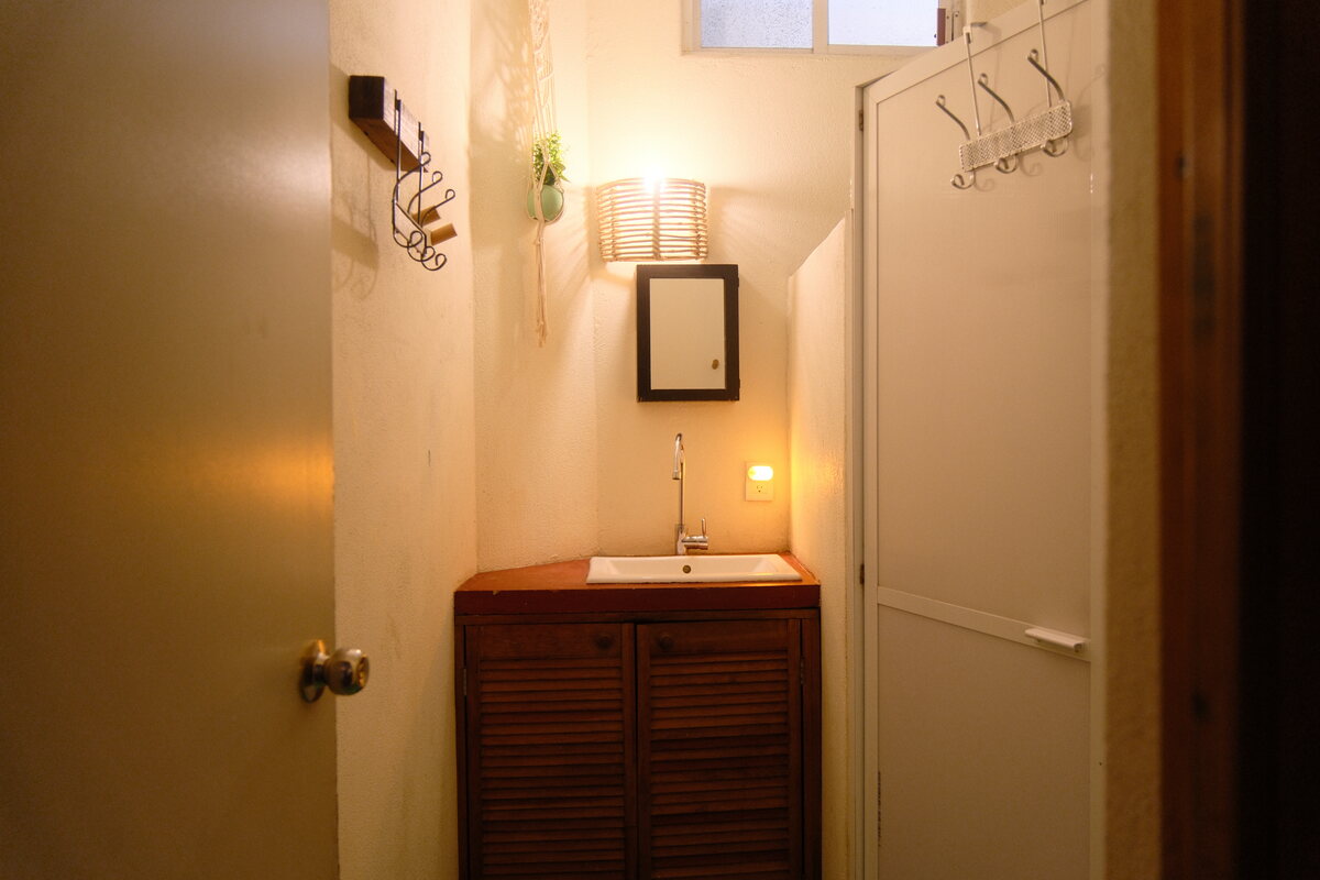 Casa Mia bathroom — vanity with a sconce and towel hooks