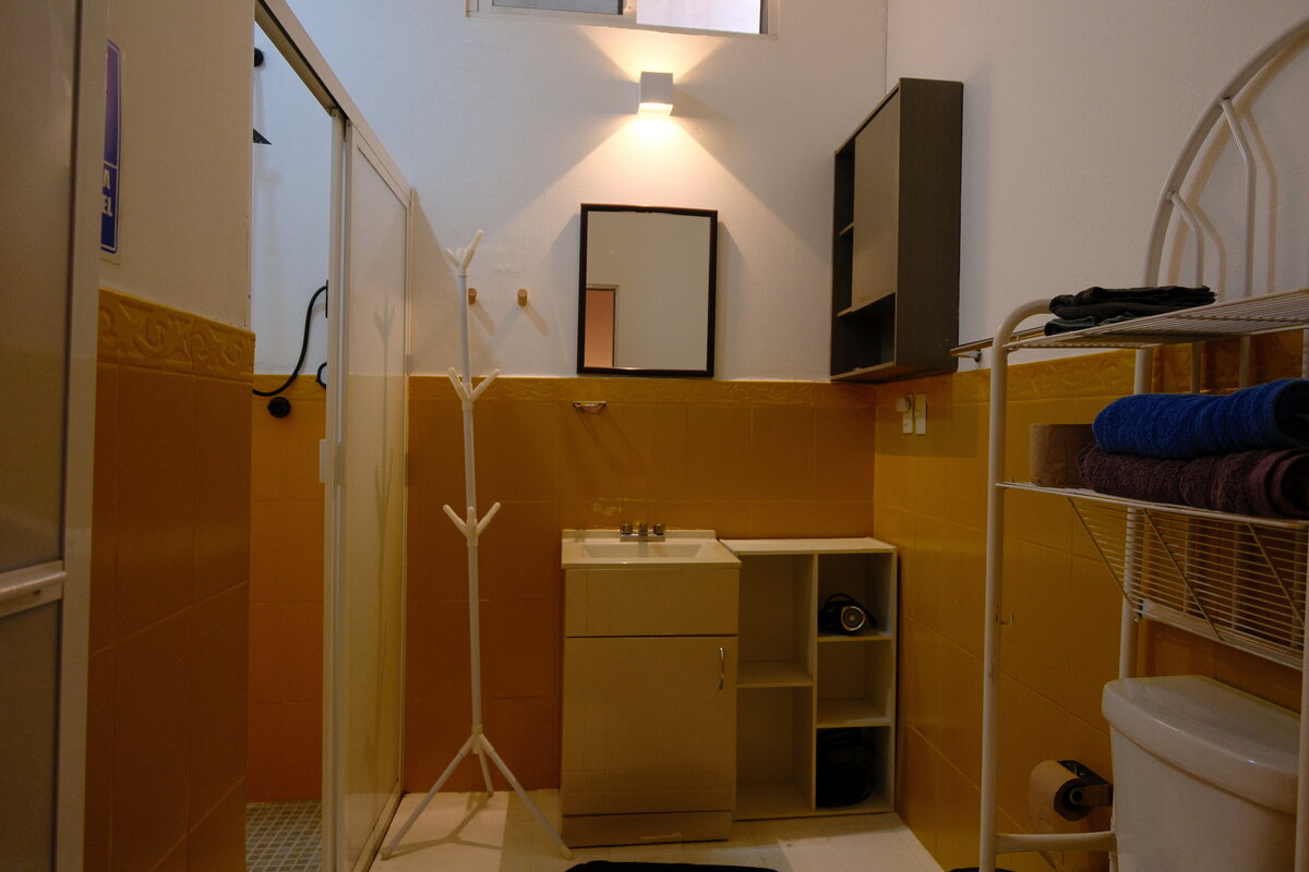 Casa Peach bathroom — glass shower, amber tile, and stocked towel rack