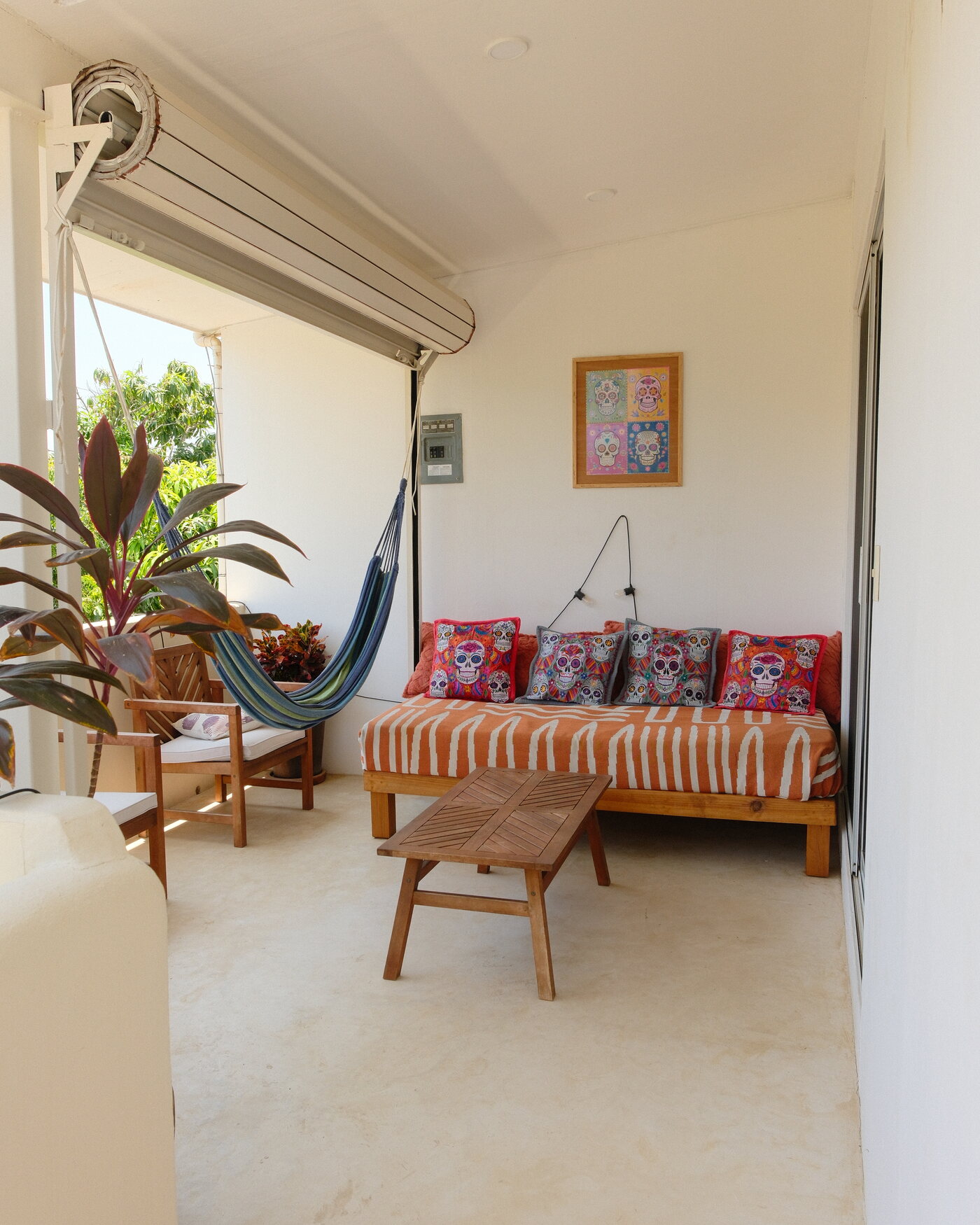 Casa Peach — covered terrace with a hammock and a daybed with sugar-skull pillows